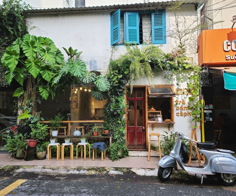 Quán cà phê vỉa hè vintage mộc mạc với bàn ghế gỗ cũ Quán cà phê vỉa hè vintage mộc mạc với bàn ghế gỗ cũ