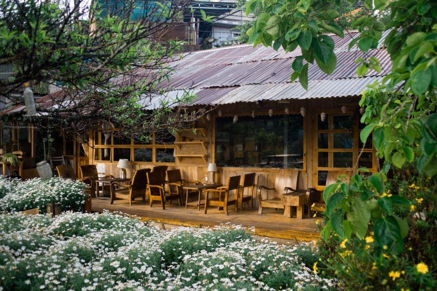 Quán cafe ngoài trời vintage với gỗ cũ, kim loại gỉ sét và ánh sáng vàng ấm Quán cafe ngoài trời vintage với gỗ cũ, kim loại gỉ sét và ánh sáng vàng ấm