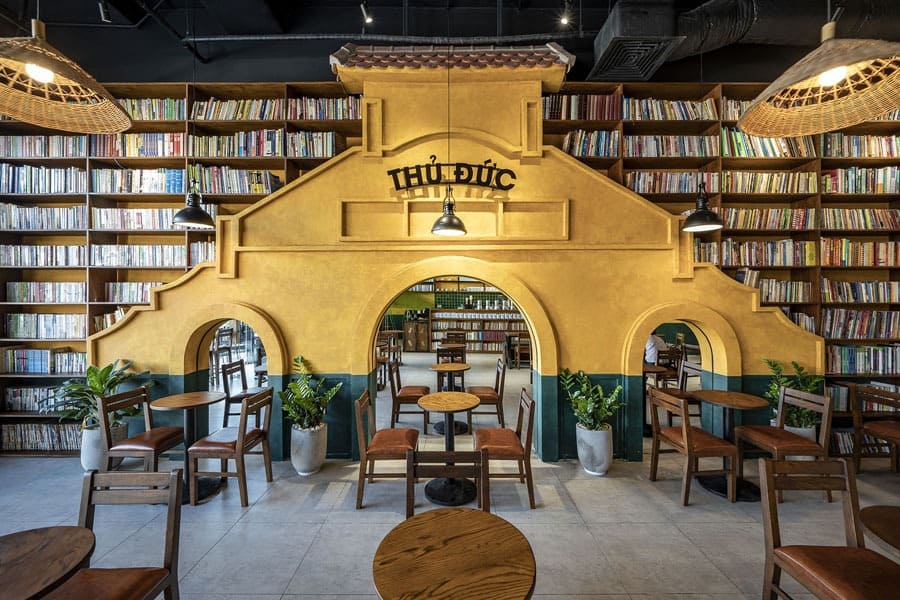 Không gian quán cafe sách hiện đại với kệ sách gỗ và bàn ghế thoải mái, tối ưu cho người yêu sách