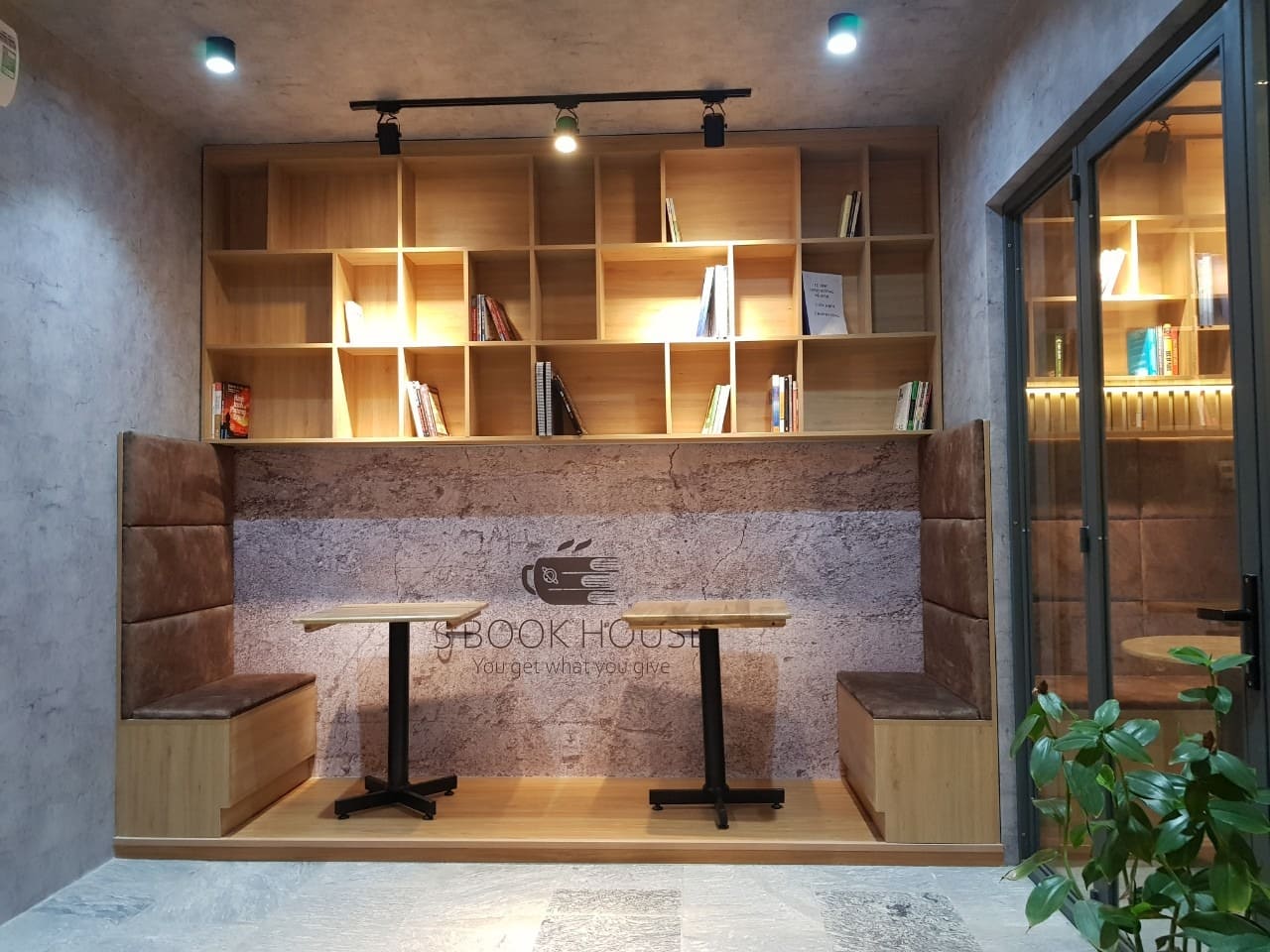 Thiết kế quán cafe sách với ghế bọc nệm, kệ sách gỗ và ánh sáng tự nhiên ấm áp