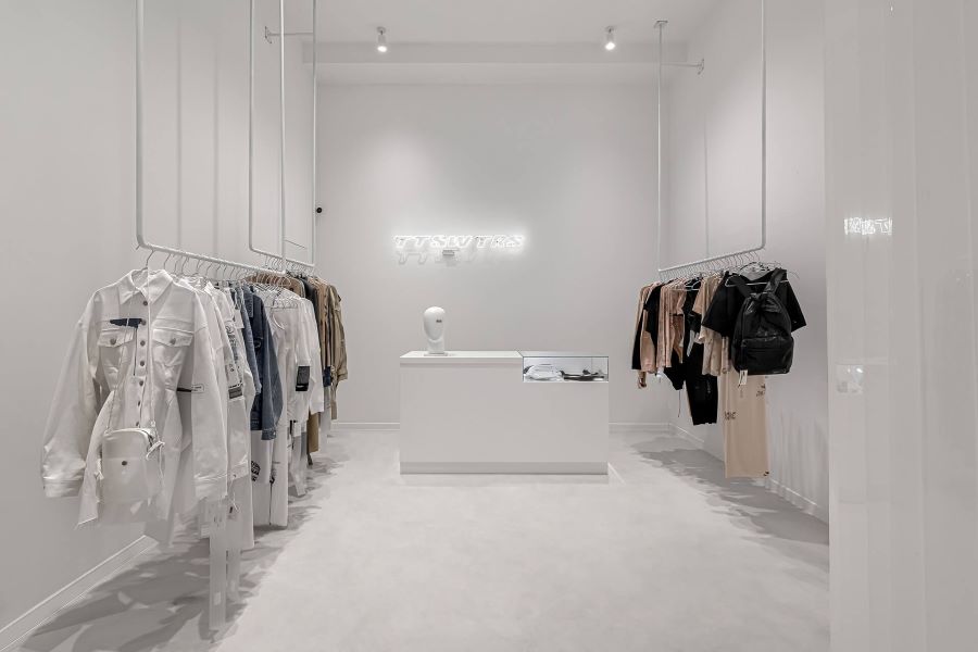 Shop quần áo 15m2 phong cách tối giản với kệ treo kim loại và tường trắng Shop quần áo 15m2 phong cách tối giản với kệ treo kim loại và tường trắng